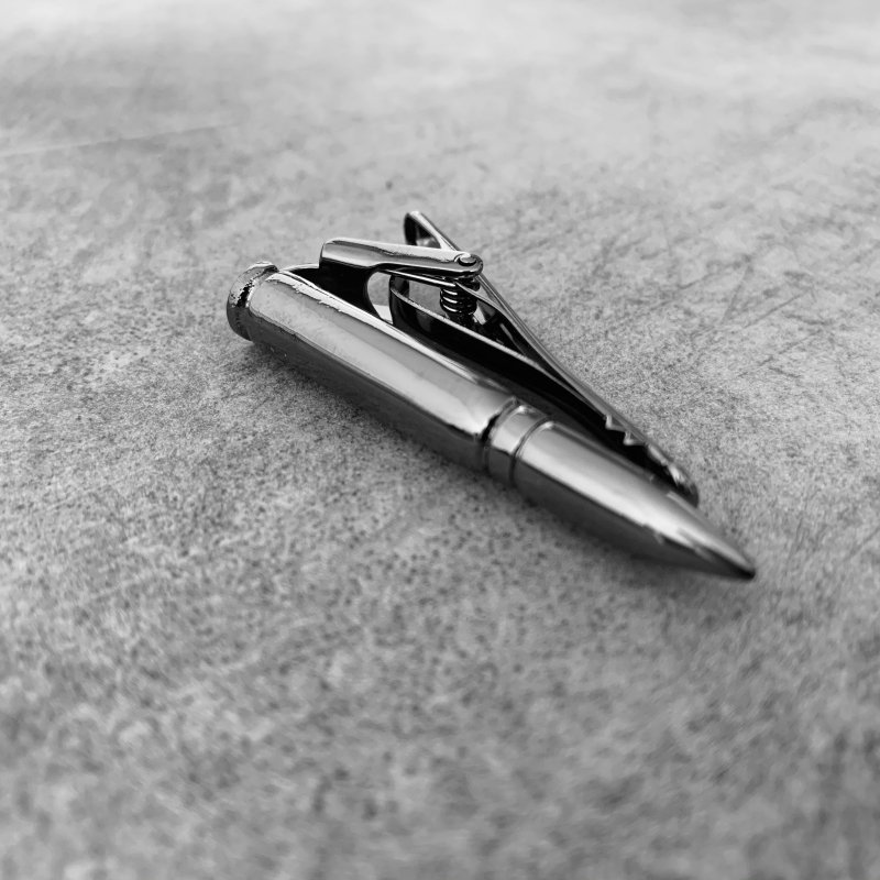 Šedá spona na kravatu Náboj 